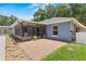Rear view of the house featuring a brick paved patio and screened enclosure at 204 Lori Ct, Umatilla, FL 32784