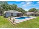Beautifully landscaped backyard with in-ground pool and a covered patio for outdoor entertaining at 204 Lori Ct, Umatilla, FL 32784