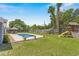 Spacious backyard with in-ground pool, playset, lush greenery, and a privacy fence at 204 Lori Ct, Umatilla, FL 32784