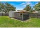 Backyard chicken coop in a fenced area, offering a unique rural touch to the property at 204 Lori Ct, Umatilla, FL 32784