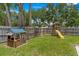 Backyard featuring a playhouse, a swing, and a slide, set in a grassy area at 204 Lori Ct, Umatilla, FL 32784