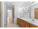 Bathroom featuring double sinks with a tile floor and natural light from a window at 204 Lori Ct, Umatilla, FL 32784