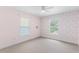 Light-filled bedroom with floral wallpaper, two windows, carpet, and ceiling fan at 204 Lori Ct, Umatilla, FL 32784