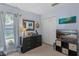 Neutral colored bedroom featuring a window, dresser, and double door closet at 204 Lori Ct, Umatilla, FL 32784