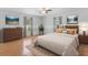 Virtual staged bedroom with wood floors, natural light and ceiling fan at 204 Lori Ct, Umatilla, FL 32784