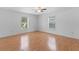 Bright bedroom with hardwood floors, a ceiling fan, and two windows that provide plenty of natural light at 204 Lori Ct, Umatilla, FL 32784