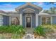 Home's front entrance is framed by lush landscaping and freshly painted trim at 204 Lori Ct, Umatilla, FL 32784
