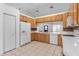 Bright kitchen features oak cabinets, tile backsplash, and white appliances at 204 Lori Ct, Umatilla, FL 32784