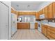 Bright kitchen features light wood cabinets, white appliances, tile countertops and mosaic backsplash at 204 Lori Ct, Umatilla, FL 32784
