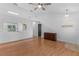 Open-concept living room with views of kitchen, black doorway, ceiling fan, and wood-look flooring at 204 Lori Ct, Umatilla, FL 32784