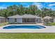 Backyard view of the private swimming pool, screened patio and landscaped yard at 204 Lori Ct, Umatilla, FL 32784