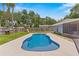 Backyard features a sparkling in-ground pool, green grass and a playset for endless summer fun at 204 Lori Ct, Umatilla, FL 32784