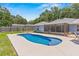 Inviting backyard with in-ground pool, screened patio, and lush green landscaping at 204 Lori Ct, Umatilla, FL 32784