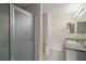 A bathroom showcasing a shower with glass doors, vanity with sink, and a neutral color scheme at 2207 Crawford Ct, The Villages, FL 32162