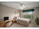 This staged bedroom features a bed, desk, and natural light, creating a cozy and inviting space at 2207 Crawford Ct, The Villages, FL 32162