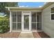 A screened front entryway providing shade, insect protection and leading into the home at 2207 Crawford Ct, The Villages, FL 32162