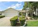 Charming home featuring a two-car garage, manicured landscaping, and a welcoming entrance at 2207 Crawford Ct, The Villages, FL 32162