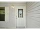 Elegant front door with decorative glass and sidelight and exterior light at 2207 Crawford Ct, The Villages, FL 32162