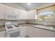 Bright kitchen featuring white appliances, countertops, and ample cabinet space at 2207 Crawford Ct, The Villages, FL 32162