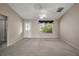 Neutral living room boasts ample natural light, a ceiling fan, and a stylish front door with decorative glass at 2207 Crawford Ct, The Villages, FL 32162