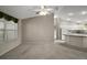 Open-concept living space with view of the kitchen and vaulted ceiling with fan and neutral colors at 2207 Crawford Ct, The Villages, FL 32162
