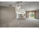Open-concept living space with view of the kitchen and vaulted ceiling with fan and neutral colors at 2207 Crawford Ct, The Villages, FL 32162