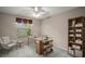 This staged office features a desk, chair, bookshelf, and natural light, creating an inspiring work environment at 2207 Crawford Ct, The Villages, FL 32162