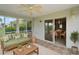 Relax on the screened patio with comfortable seating, a ceiling fan, and dining table with chairs at 2207 Crawford Ct, The Villages, FL 32162