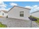 The backyard of the home features gravel landscaping, a small window, and a satellite dish at 2237 Jetta Way, The Villages, FL 32162