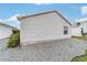 Exterior view of a home with simple gravel landscaping and a glimpse of a neighboring house at 2237 Jetta Way, The Villages, FL 32162