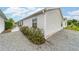 A view of the home's exterior with neat gravel landscaping and a glimpse of the screen patio at 2237 Jetta Way, The Villages, FL 32162