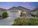 Charming single-story home with light grey siding, a two-car garage, and a well-manicured front yard with a white picket fence at 2237 Jetta Way, The Villages, FL 32162