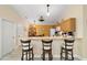 Bright kitchen with a breakfast bar, wooden cabinets, stainless steel appliances, and adjacent dining area at 2237 Jetta Way, The Villages, FL 32162