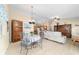 Open-concept living area with dining space, kitchen, and cozy seating arrangement, featuring contemporary flooring and decor at 2237 Jetta Way, The Villages, FL 32162