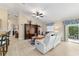 Spacious living room with bar seating and an entertainment center, flowing to outdoor patio space at 2237 Jetta Way, The Villages, FL 32162