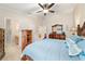 Comfortable bedroom features a wood bedroom set, ceiling fan, and ensuite bathroom for a relaxing retreat at 2237 Jetta Way, The Villages, FL 32162