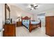 Spacious bedroom featuring a ceiling fan, natural light, and wooden furniture at 2237 Jetta Way, The Villages, FL 32162