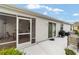 A covered patio with a ceiling fan, screen door, grill, and furniture with access to the home's interior at 2237 Jetta Way, The Villages, FL 32162