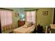 Cozy bedroom featuring a comfortable bed, dresser, and serene green walls at 235 Rockmoore Ct, Deland, FL 32720