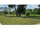 A quiet community park featuring mature trees, a swing, and a walking path at 235 Rockmoore Ct, Deland, FL 32720