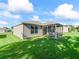 Beautiful backyard with a screened porch and lush green lawn, ideal for outdoor activities at 2369 Five Forks Trl, The Villages, FL 32162