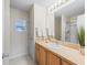 Bathroom vanity featuring wood cabinetry, a sink, a framed mirror, and a shower with a glass door at 2369 Five Forks Trl, The Villages, FL 32162