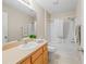 Bright bathroom with oak cabinetry, a sink, a mirror, and a shower-tub combination at 2369 Five Forks Trl, The Villages, FL 32162
