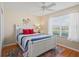 Bedroom featuring a white bed frame, colorful bedding, ceiling fan, and natural lighting at 2369 Five Forks Trl, The Villages, FL 32162