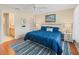 Well-lit bedroom with ensuite bathroom, blue bedding, and white wicker nightstands at 2369 Five Forks Trl, The Villages, FL 32162