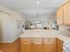 Open-concept kitchen with bar seating that flows into the adjacent dining and living areas, creating a seamless space at 2369 Five Forks Trl, The Villages, FL 32162