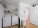 Efficient laundry room with washer, dryer, shelving, and convenient access to the home at 2369 Five Forks Trl, The Villages, FL 32162
