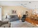 Cozy living room with vaulted ceilings, ceiling fan, and a comfortable gray sofa and recliner at 2369 Five Forks Trl, The Villages, FL 32162