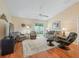 Spacious living room featuring comfortable seating, a ceiling fan, and sliding glass doors to a serene outdoor space at 2369 Five Forks Trl, The Villages, FL 32162