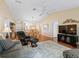 Inviting living area featuring vaulted ceilings, a neutral color palette, hardwood floors, and seamless transition to dining and kitchen at 2369 Five Forks Trl, The Villages, FL 32162
